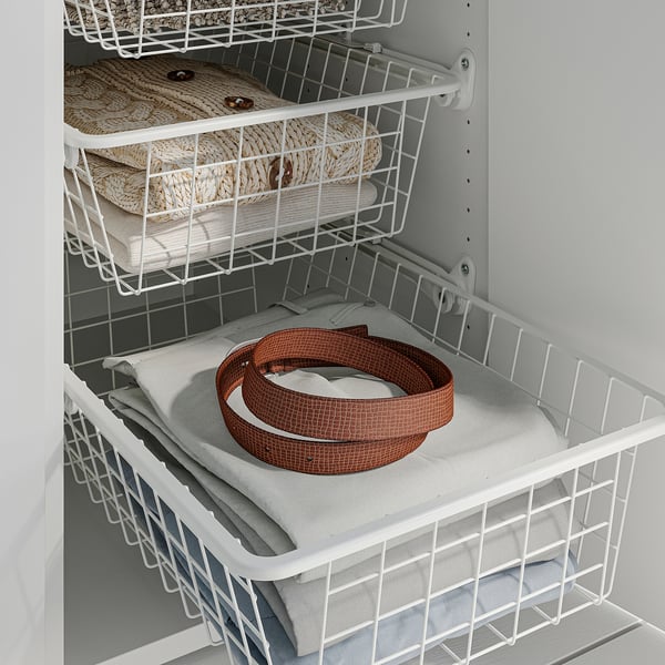 Wire baskets in cabinet, one holding folded clothes and another with rolled belt, allowing air circulation and easy access.