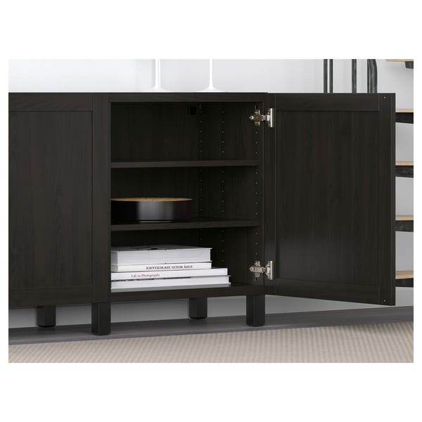 Black wooden cabinet with adjustable shelves and soft-closing doors, storing books and a dish.