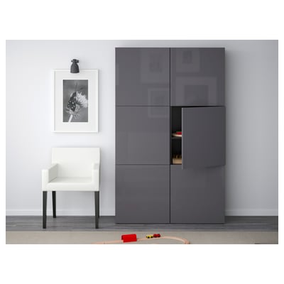 Modern living room with grey cabinets, open door, toys on rug, black lamp, floral art.