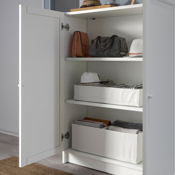 BILLY bookcase with shelves holding handbags and boxes.