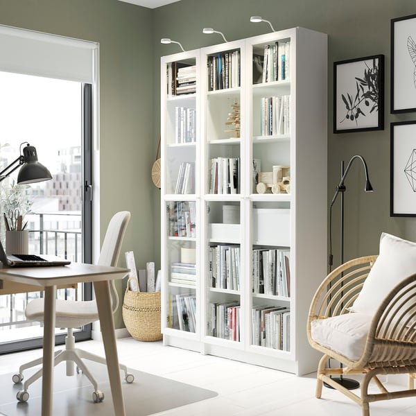 Home office with BILLY bookcase, desk, chairs, and lights.