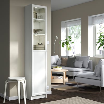 Minimalist living room with BILLY shelf, decor, grey sofa, coffee table, and natural light.