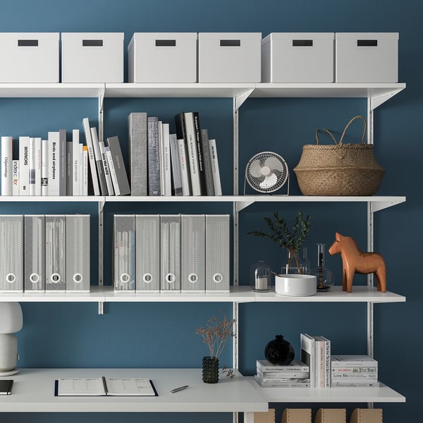 White wall-mounted shelves with books, boxes, and decorative items. Perfect for organised storage, fitting numerous items in limited space.