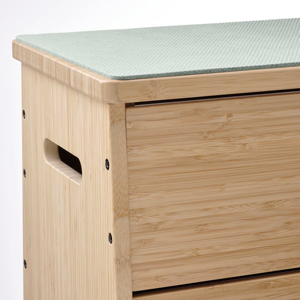 Sturdy bamboo storage bench with soft, textured top pad. Detailed craftsmanship visible in corners and handles.