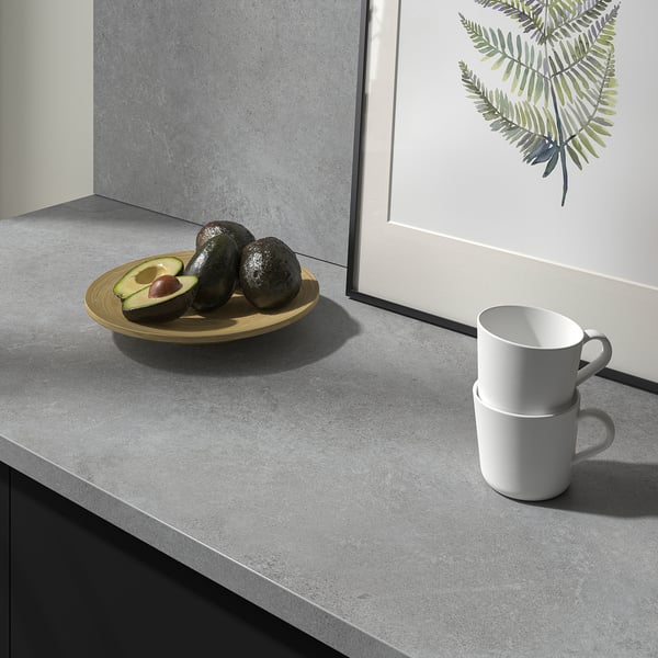 Countertop with avocados and mugs, showcasing EKBACKENs durability and easy cleaning. A practical and stylish kitchen surface.