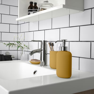 Modern bathroom sink with yellow soap dispenser and toothbrush holder from EKOLN series.