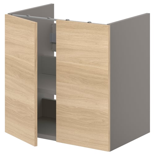 An ENHET light brown wooden bathroom cabinet with grey interior and shelves. Two doors are open, revealing storage space.
