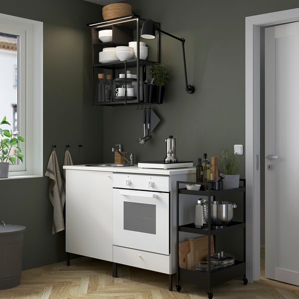 Modern kitchen: white cabinets, dark decor, open shelves, green walls, wooden floor.