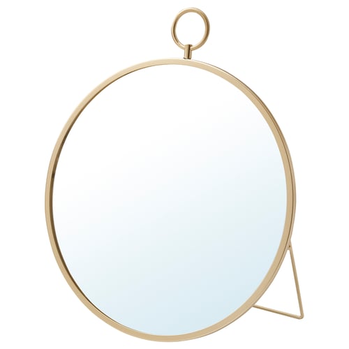 A gold-colored GRYTÅS mirror. It has a round shape with a minimalist design. The mirror can be hung or stood.
