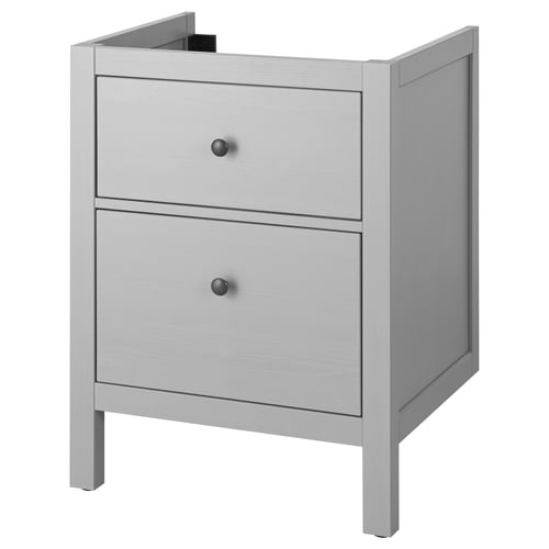 Light-colored wooden bedside table with two drawers, each featuring black knobs, standing on four legs.