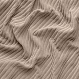 Close-up of thick, textured beige corduroy showcasing deep wales and soft touch.
