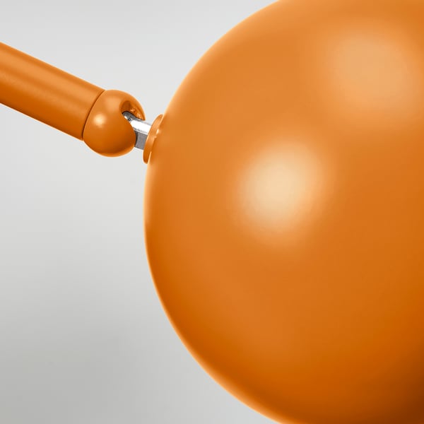 Adjustable desk lamp with smooth, flawless orange finish. Rounded design, metal body, and arm connexion detail visible.