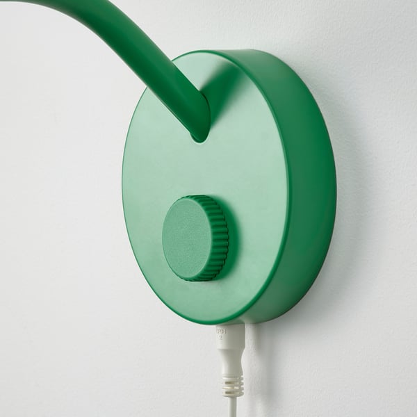 Green wall-mounted lamp with adjustable neck and circular base; modern, sleek design.