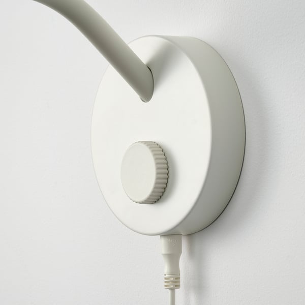 Wall-mounted modern light fixture with sleek design and adjustable arm. Off-white colour.