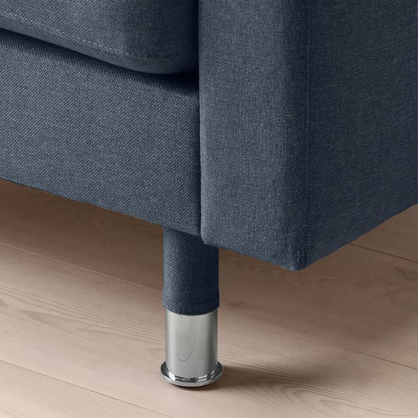 Close-up of a modern, grey fabric armchair with sleek chrome legs.