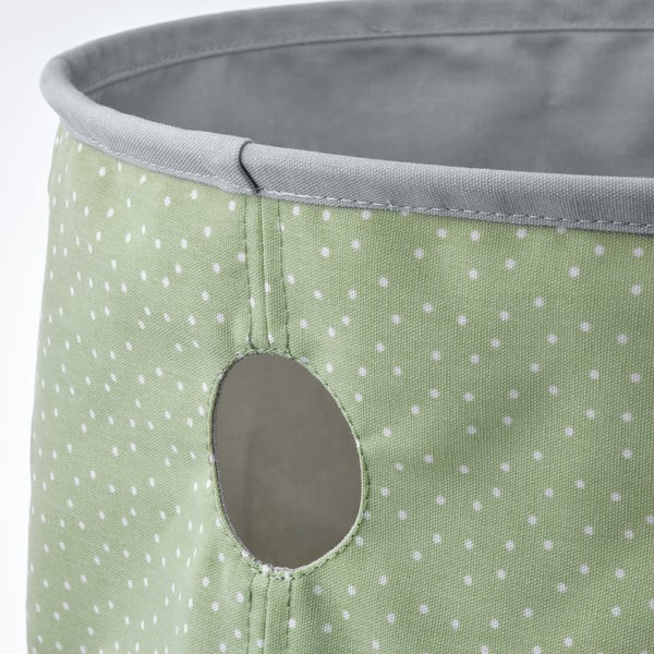 Green fabric bin with white polka dots, sturdy and reversible, good for storage.