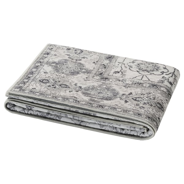 Folded grey LOKALTÅG yoga mat, featuring intricate patterns, made from recycled polyester and synthetic rubber.