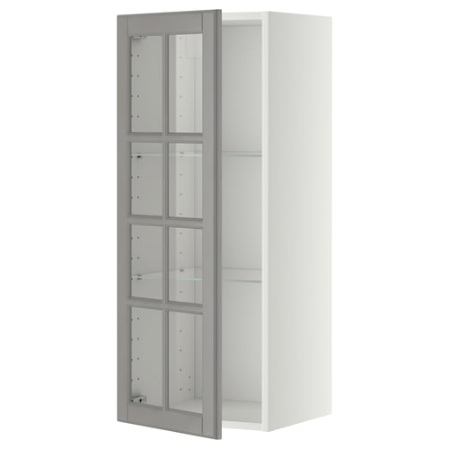 A white METOD wall cabinet with grey glass doors, featuring bevelled edges and adjustable shelves.