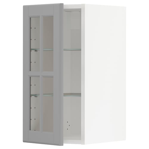 A white METOD kitchen cabinet with grey-tinted glass doors and adjustable glass shelves.