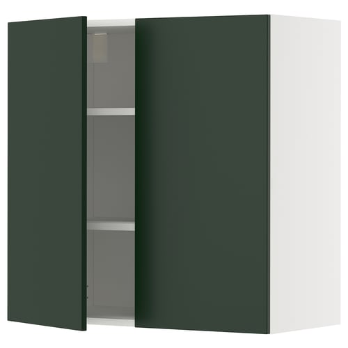 A green kitchen cabinet with one door open, revealing adjustable shelves inside.