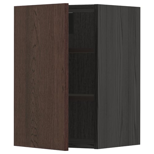A dark brown kitchen cabinet with a door open, exposing a shelf inside.