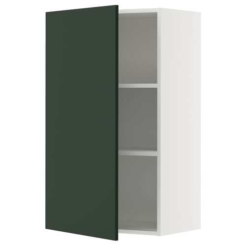 A METOD kitchen cabinet with a deep green havstorp door, featuring a white frame and adjustable shelves.
