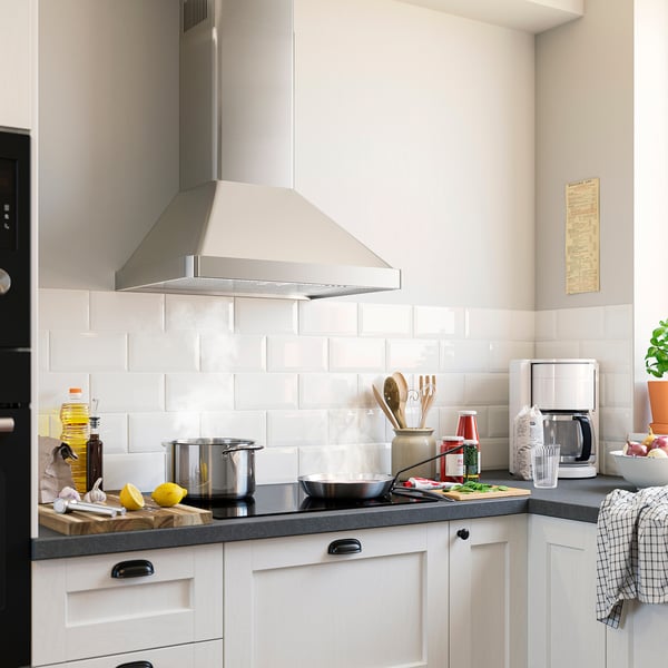 Modern kitchen with a large, stainless steel NILSBYN pyramid hood, white cabinets, black countertop, and various cooking utensils.