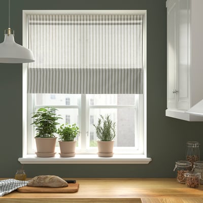 Kitchen window with RINGBLOMMA blind, plants, bread, jars, pendant lamp.