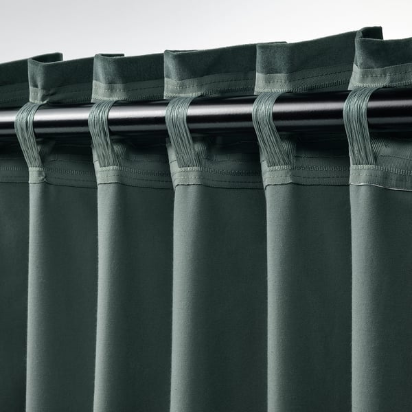 Green velvet curtains hung on rod, showing hooks and folds.