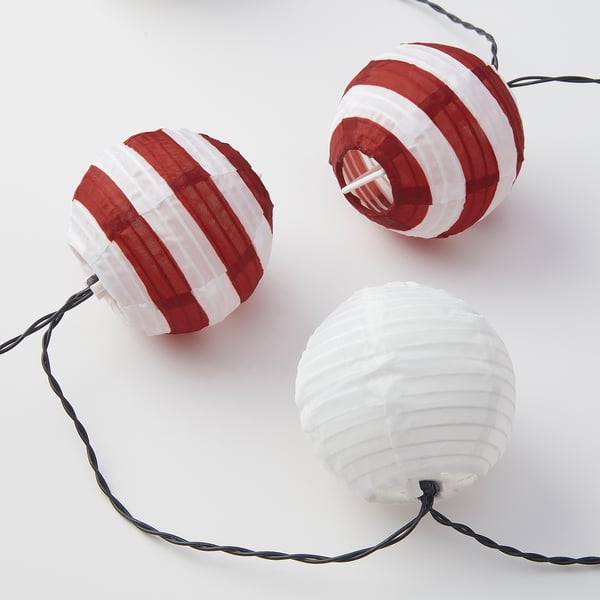 Three spherical string lights, two with red and white stripes, one plain white, all interconnected, displayed against a light background.