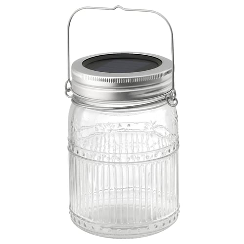 A SOLVINDEN solar jar lamp in clear glass with a silver lid and handle. Its designed for decorative, eco-friendly lighting both indoors and out.
