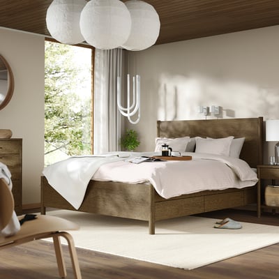 Minimalist bedroom with TONSTAD wood bed, white linens, unique light fixture, plant, and large window.