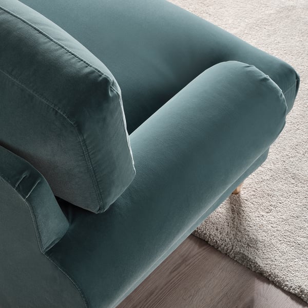 Teal sofa with plush cushions & wooden legs. Elegant, inviting design.