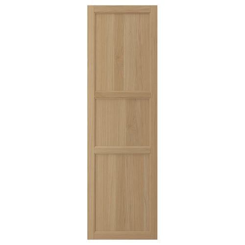 A VEDHAMN kitchen cabinet door in light brown. The door has a wooden frame with a panelled design.