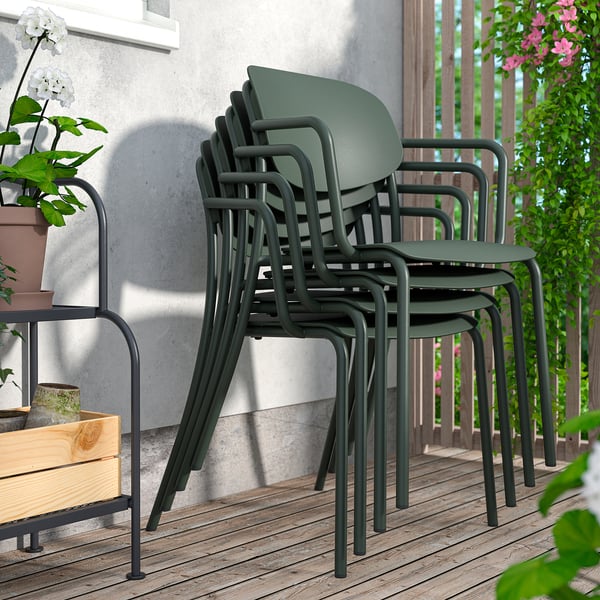 Stacked dark green chairs on patio, ideal for outdoor use.