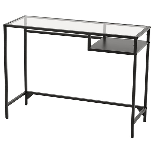 Modern black VITTSJÖ desk with glass top, metal frame, and pull-out shelf.