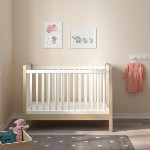 Wooden crib ÄLSKVÄRD in nursery with rug and wall art