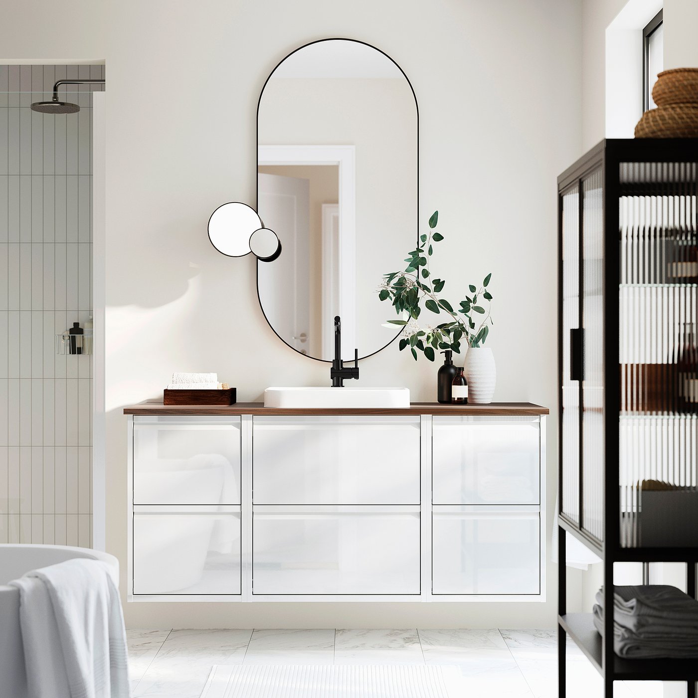 Modern bathroom with ÄNGSJÖN vanity, mirror, and black towel shelf.