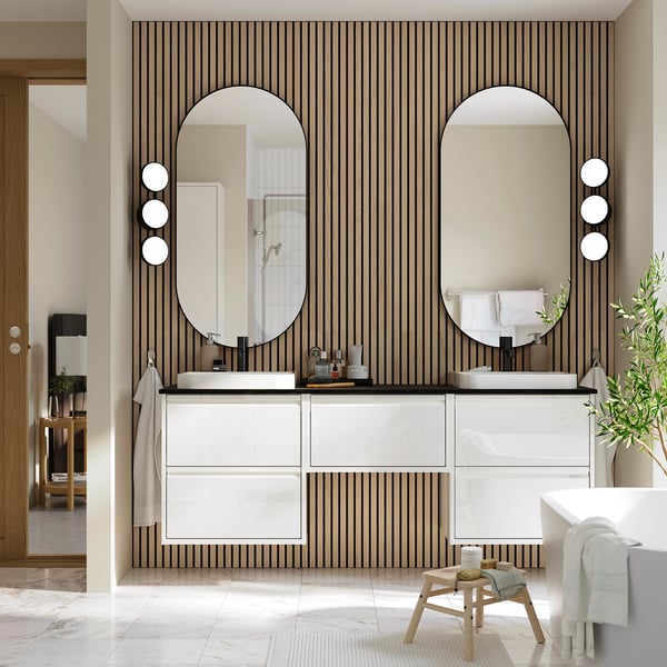 Modern bathroom with ÄNGSJÖN cabinet, mirrors, marble counter, striped walls, & tall vanity.