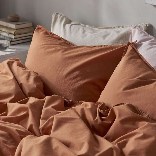 Soft, earth-toned bedding set with comfortable, pre-washed cotton on a neatly made bed.