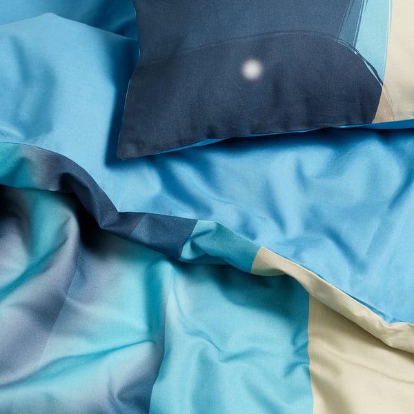 Blue duvet cover with smooth texture and subtle patterns visible, likely made of cotton and lyocell for comfort.