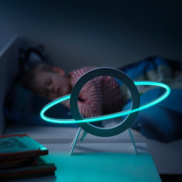 Glowing planet lamp on bedside, blue light calms child.