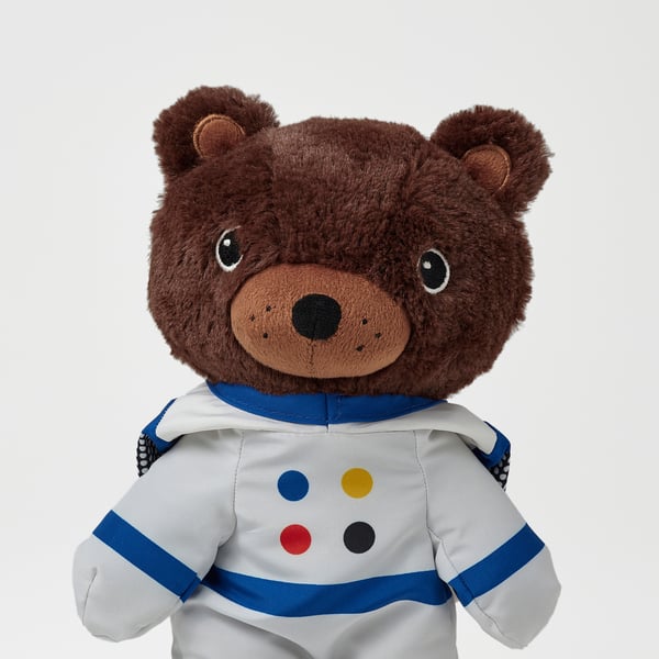 Plush bear in astronaut suit, high-quality, white fur, blue accents, multi-color dots, embroidered.