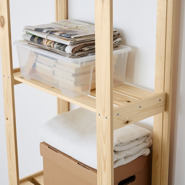 Wooden storage shelf with boxes and folded towels.
