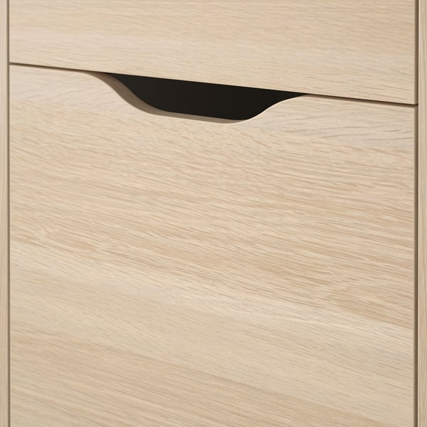 Wooden drawer unit close-up, smooth light wood finish, cutout handle.
