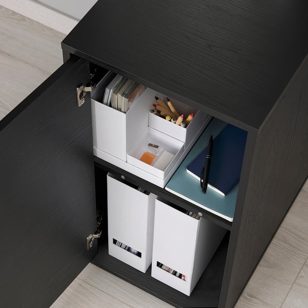 Black ALEX unit with open doors revealing shelves and storage boxes, including a laptop and stationery.