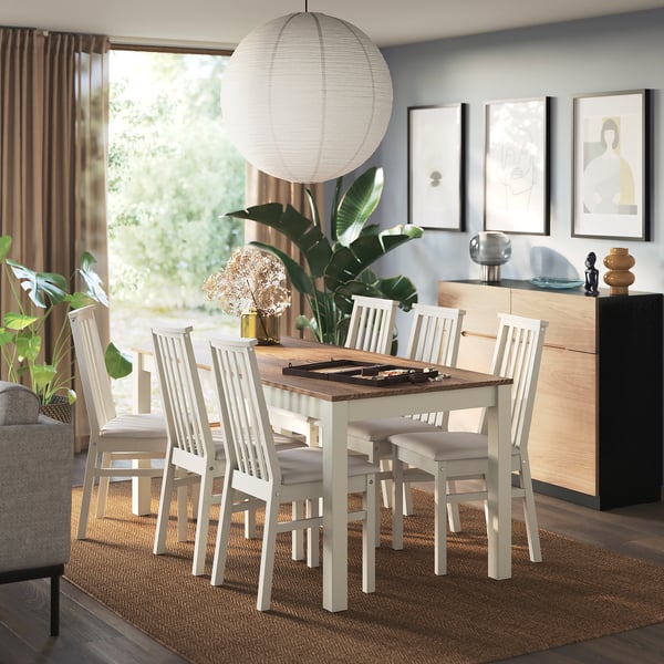 Modern dining area with ÅLHULT chair set around wooden table, cushioned seats, pendant lamp, sideboard with decor, rug, curtains, and plants.