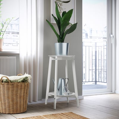 ALPVIDE white wood steel plant stand, grey tray, holding tall green plant near basket, door, window.