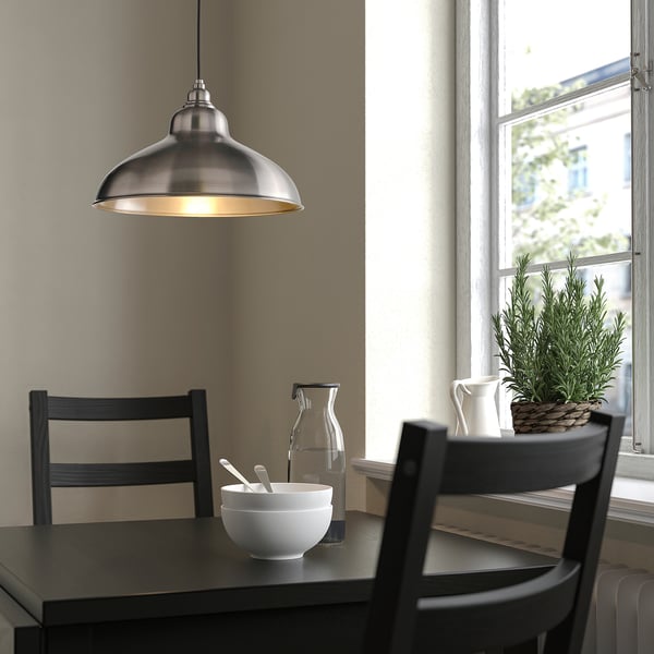 ANKARSPEL lamp over dining table with dark wood, chairs, and decor.