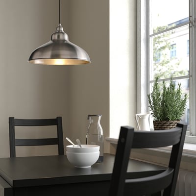 ANKARSPEL lamp over dining table with dark wood, chairs, and decor.